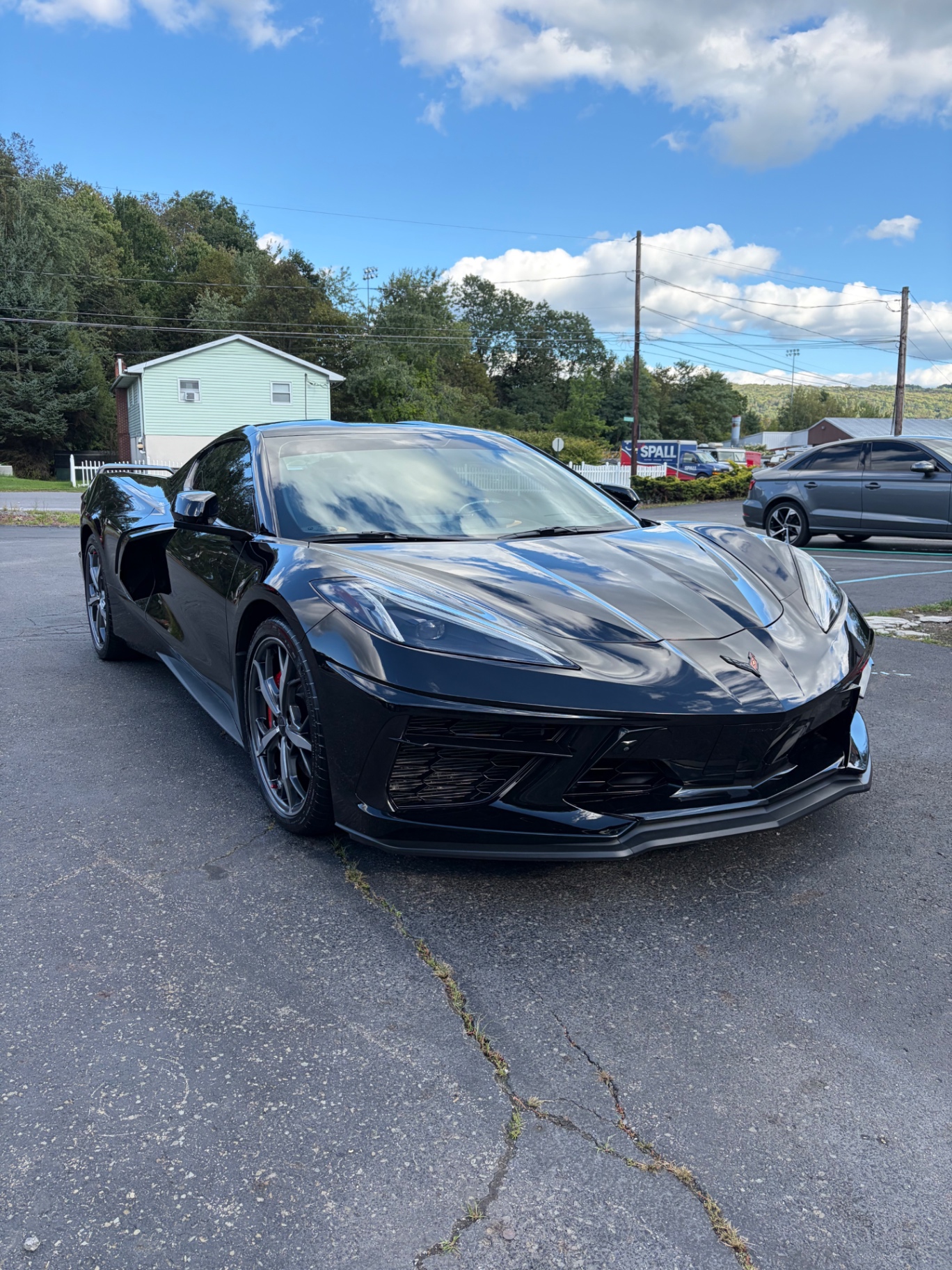 Black Chevrolet Corvette C8 after paint correction, mirror-gloss finish reflecting the sky