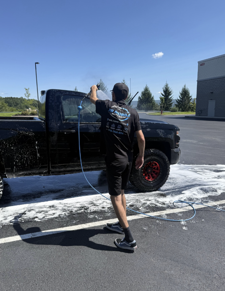Anthony washing a black pickup truck