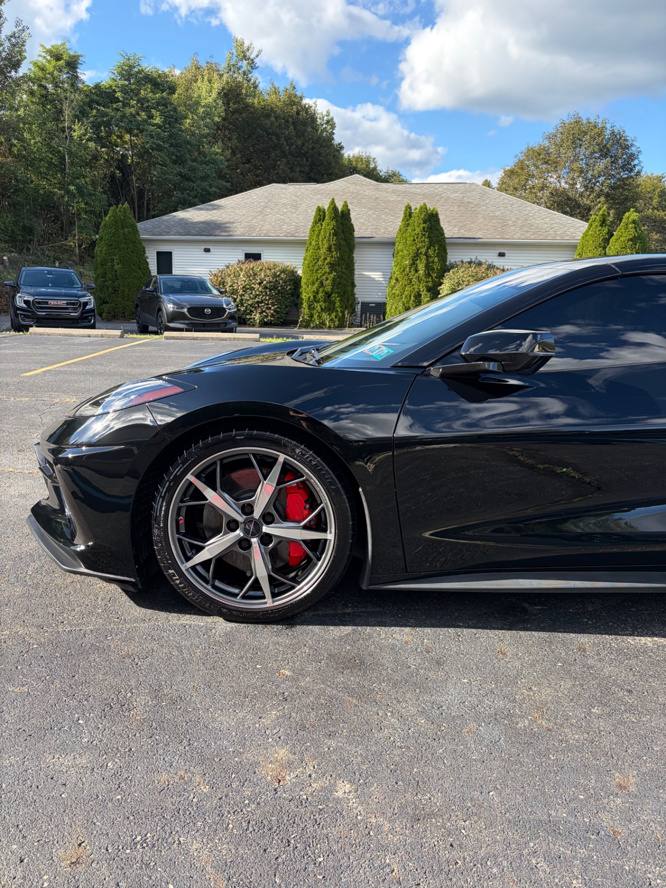 Black Chevrolet Corvette C8 wheel with red brake calipers after detail